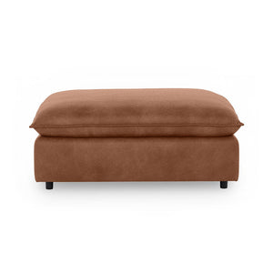 Classic Home Caplan upholstered ottoman with a plush fabric finish, serving as a versatile footrest or accent piece.