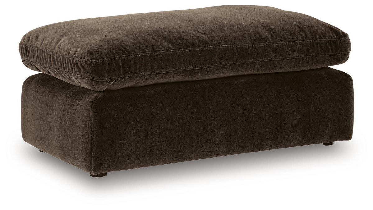 Benchcraft® Maxton Heights upholstered ottoman with plush fabric and wooden legs, used as a footrest or versatile accent piece.