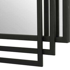 Uttermost Amherst wall mirror with a sleek, modern frame, hanging on a wall in a contemporary interior.