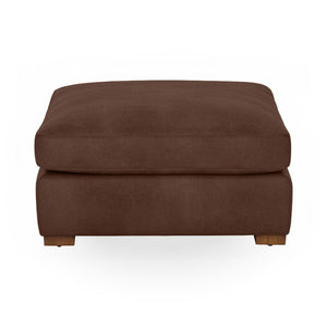 Classic Home Audrey upholstered ottoman with plush fabric and wooden legs, serving as a stylish footrest or accent piece.
