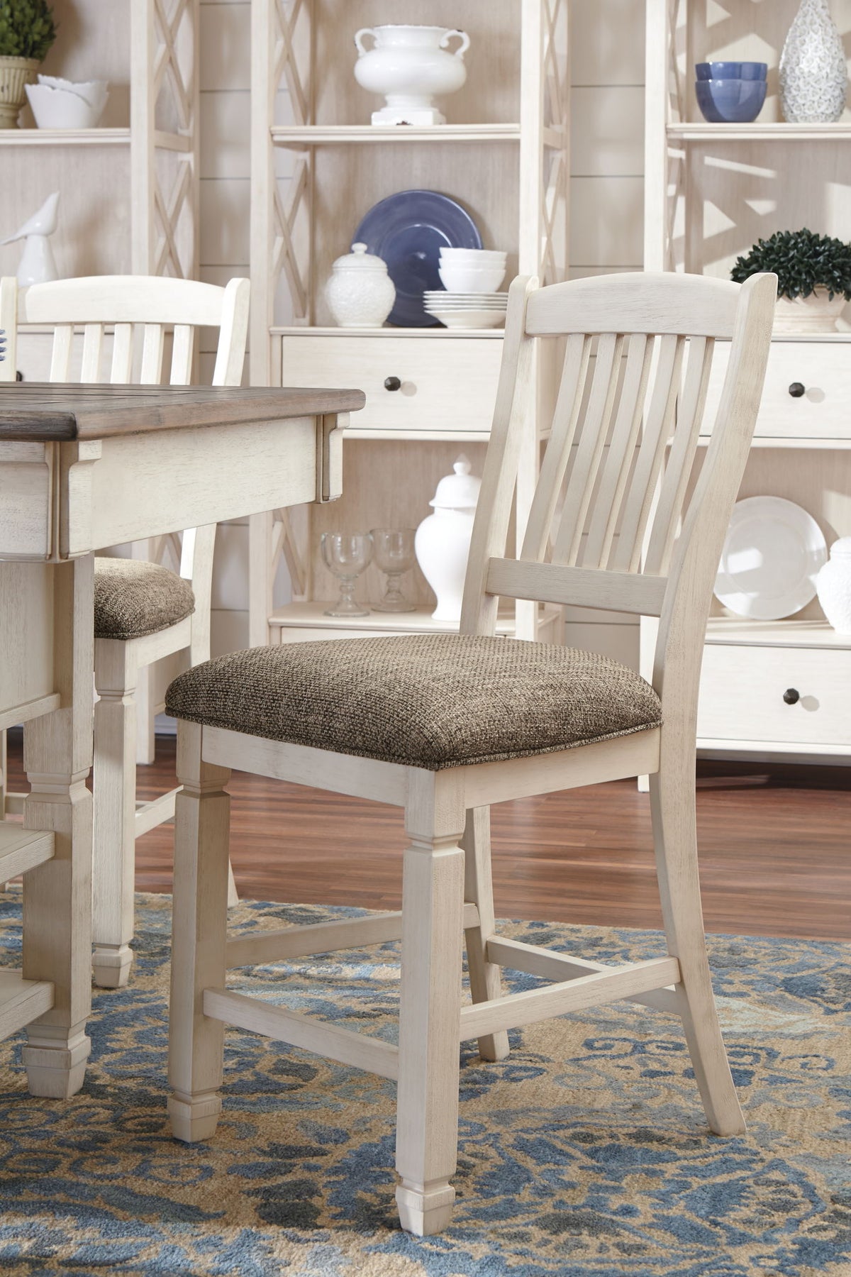 Set of two beige upholstered barstools by Signature Design Ashley, showing padded seats and wooden legs.