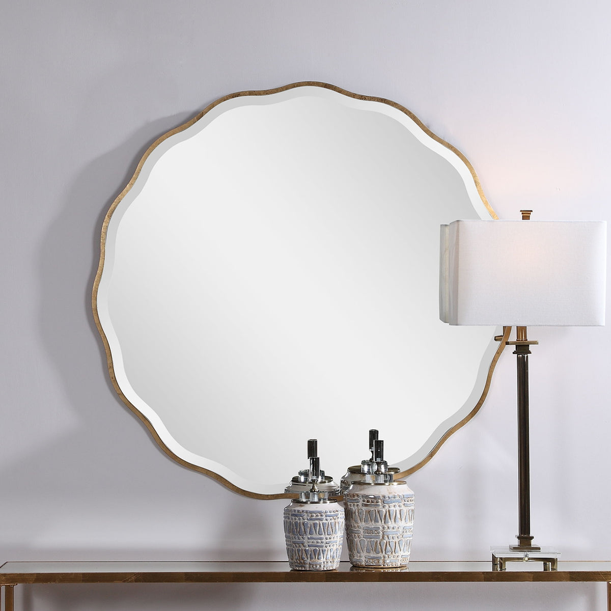 Uttermost Aneta round wall mirror with a sleek, modern frame hanging on a wall in a stylish home interior.