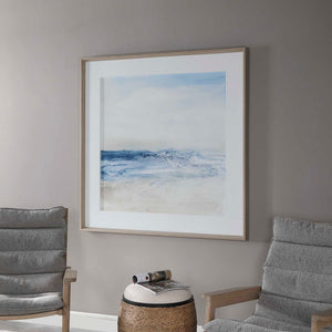 Framed print titled "Surf And Sand" by Uttermost featuring a blue coastal beach scene with waves and sand.