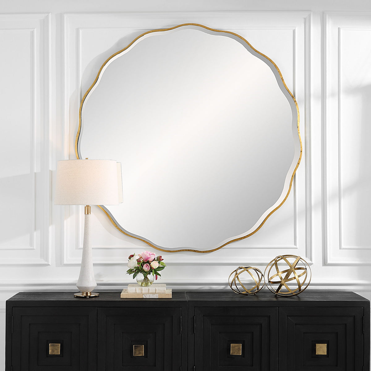 Uttermost Aneta round wall mirror with a sleek metal frame hanging on a modern wall.