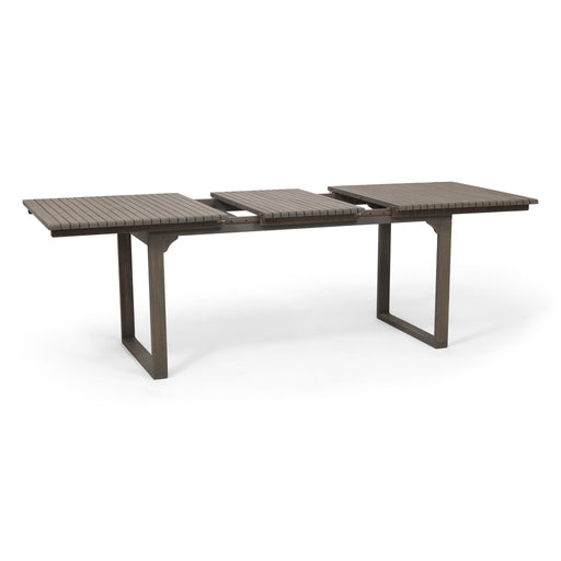 Outdoor expandable acacia wood dining table with U-shaped legs by Noble House, showing the table's natural wood grain and expanded size.