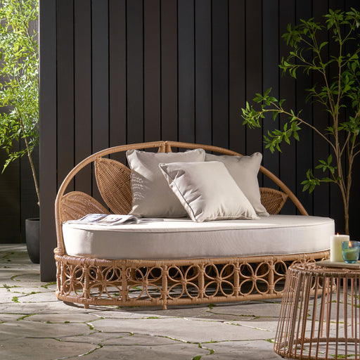 Noble House outdoor wicker daybed with beige cushions and pillows, light brown finish, perfect for patio lounging.