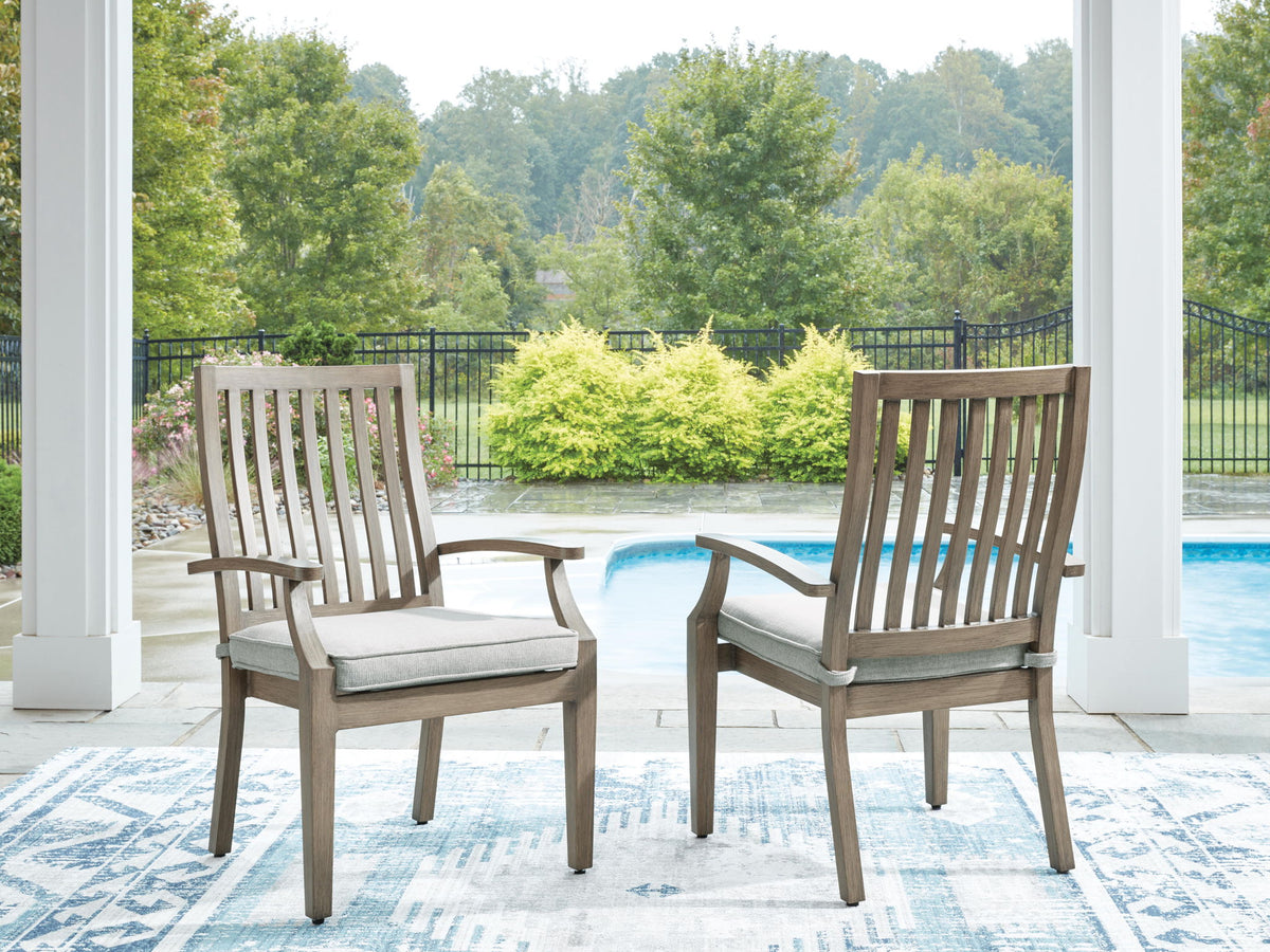 Set of two brown and beige Rainier Ranch arm chairs with cushions by Signature Design in a stylish living room setting.
