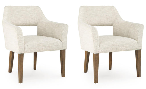 Set of two Benchcraft® Marxmore beige and brown upholstered dining arm chairs with padded seats and curved backs.