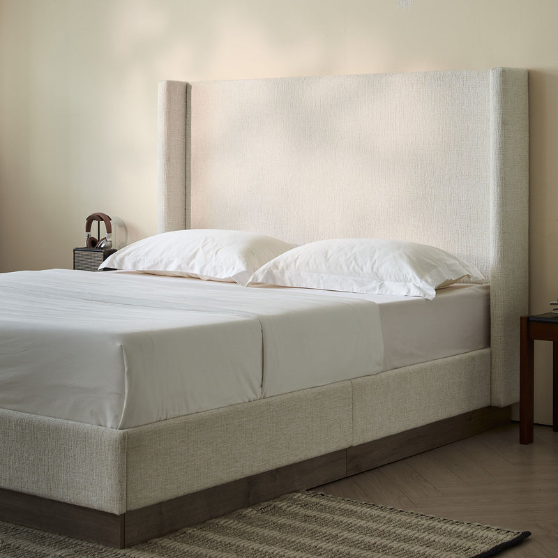 House & Home Furniture Hosford minimalist upholstered wingback bed with wood platform base, beige fabric, and padded headboard.
