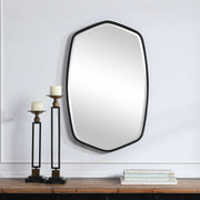 Uttermost Duronia iron wall mirror with a sleek, modern frame, hanging on a neutral wall for stylish home decor.