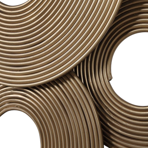 Gold rings wall decor by Uttermost, featuring overlapping gold metal rings mounted on a neutral wall for modern interior style.
