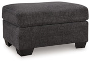 Benchcraft® upholstered ottoman with plush fabric and wooden legs, perfect as a versatile living room accent piece.