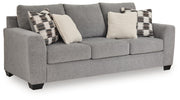 Benchcraft stationary sofa with plush cushions and neutral fabric, showcasing a modern living room setup.