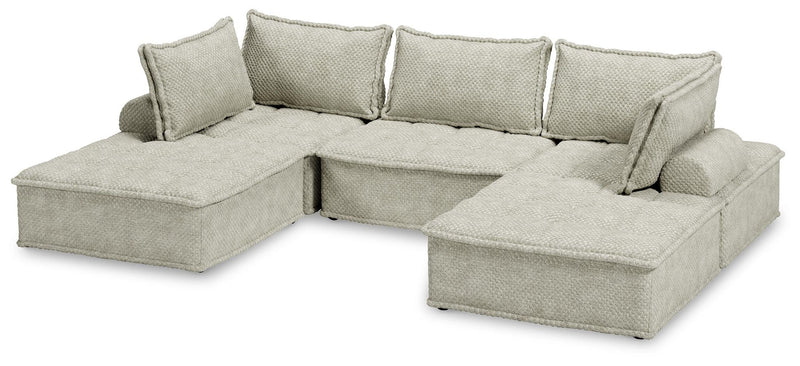 Signature Design by Ashley stationary sectional sofa with plush cushions and modern design, shown in a contemporary living room setting.