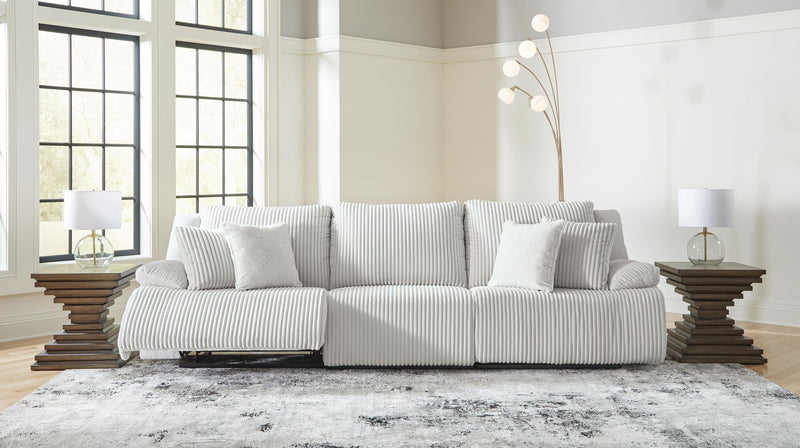 Signature Design by Ashley reclining sectional sofa with plush cushions and a modern design, shown in a living room setting.