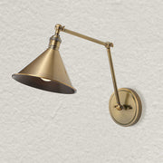 Uttermost Exeter gold 1-light adjustable sconce with modern design and sleek finish, mounted on a wall.