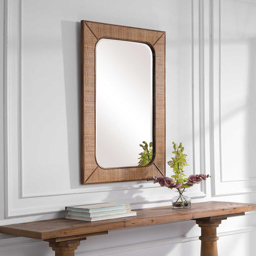 Light brown rattan wall mirror by Uttermost, Tahiti style, featuring a round frame with woven rattan details.