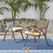 Set of two Noble House Helen outdoor dining chairs in gray and creme acacia wood with slatted seats and armrests.