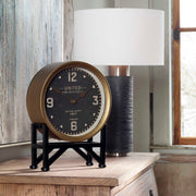 Black Shyam tabletop clock by Uttermost with a sleek, modern design and round face on a flat surface.