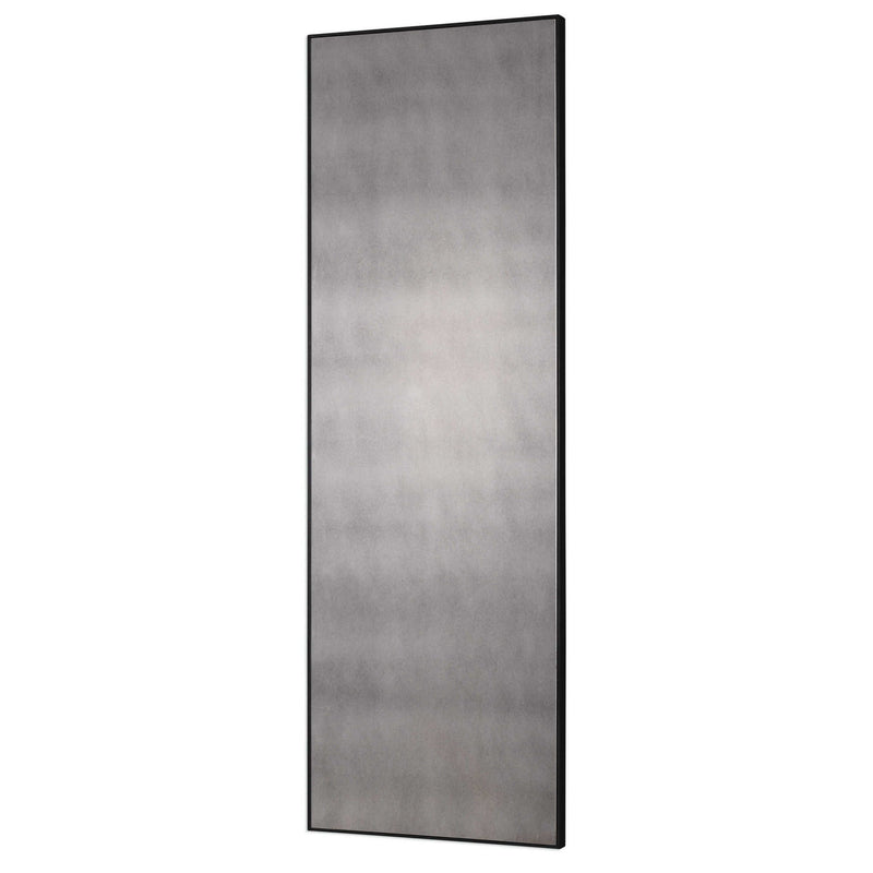 Uttermost Burwell oversized black antiqued wall mirror with a bold, antique-inspired frame hanging on a wall.