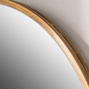 Herleva gold oval wall mirror by Uttermost with a sleek frame, hanging on a wall with a modern decor background.