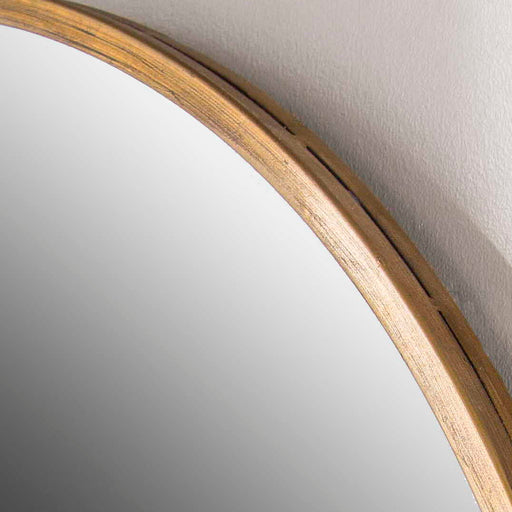 Herleva gold oval wall mirror by Uttermost with a sleek frame, hanging on a wall with a modern decor background.