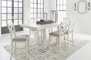 Signature Design by Ashley Robbinsdale rectangular counter height dining extension table set with six matching chairs in a modern dining room setting.