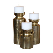Set of three Amina antique brass candleholders by Uttermost, featuring elegant sculptural designs perfect for decorative display.