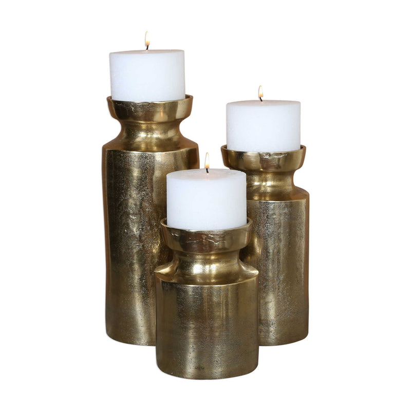 Set of three Amina antique brass candleholders by Uttermost, featuring elegant sculptural designs perfect for decorative display.
