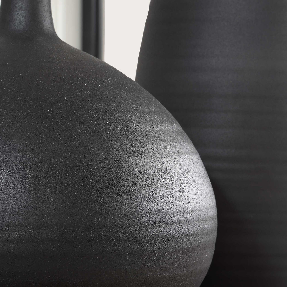 Set of two black Uttermost Bower vases with sleek, modern design, ideal for decorative display or floral arrangements.