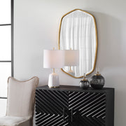 Uttermost Duronia iron wall mirror with a sleek, modern frame hanging on a wall, reflecting light and interior space.