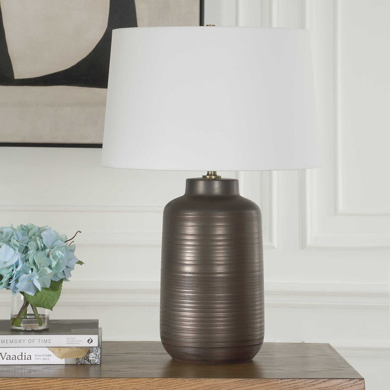 Uttermost Calderone bronze table lamp with a sleek, modern design and a cylindrical base, perfect for contemporary home decor.