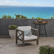 Noble House Brava mid-century modern arm chair with water-resistant cushions, featuring sleek wooden legs and plush upholstery.