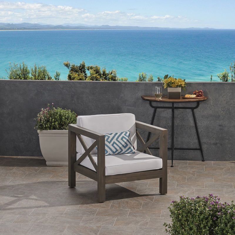 Noble House Brava mid-century modern arm chair with water-resistant cushions, featuring sleek wooden legs and plush upholstery.
