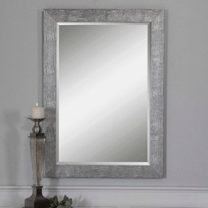 Uttermost Tarek silver wall mirror with a sleek, modern frame hanging on a wall, showcasing reflective surface and contemporary design.