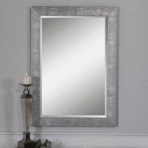 Uttermost Tarek silver wall mirror with a sleek, modern frame hanging on a wall, showcasing reflective surface and contemporary design.