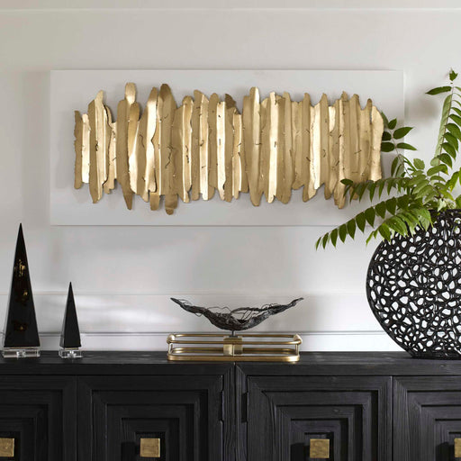 White and gold metal wall decor by Uttermost featuring an intricate, modern design for stylish interior wall decoration.