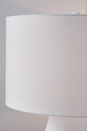 White and navy metal table lamp from Dashland by Signature Design Ashley, featuring a sleek modern design with a cylindrical base.