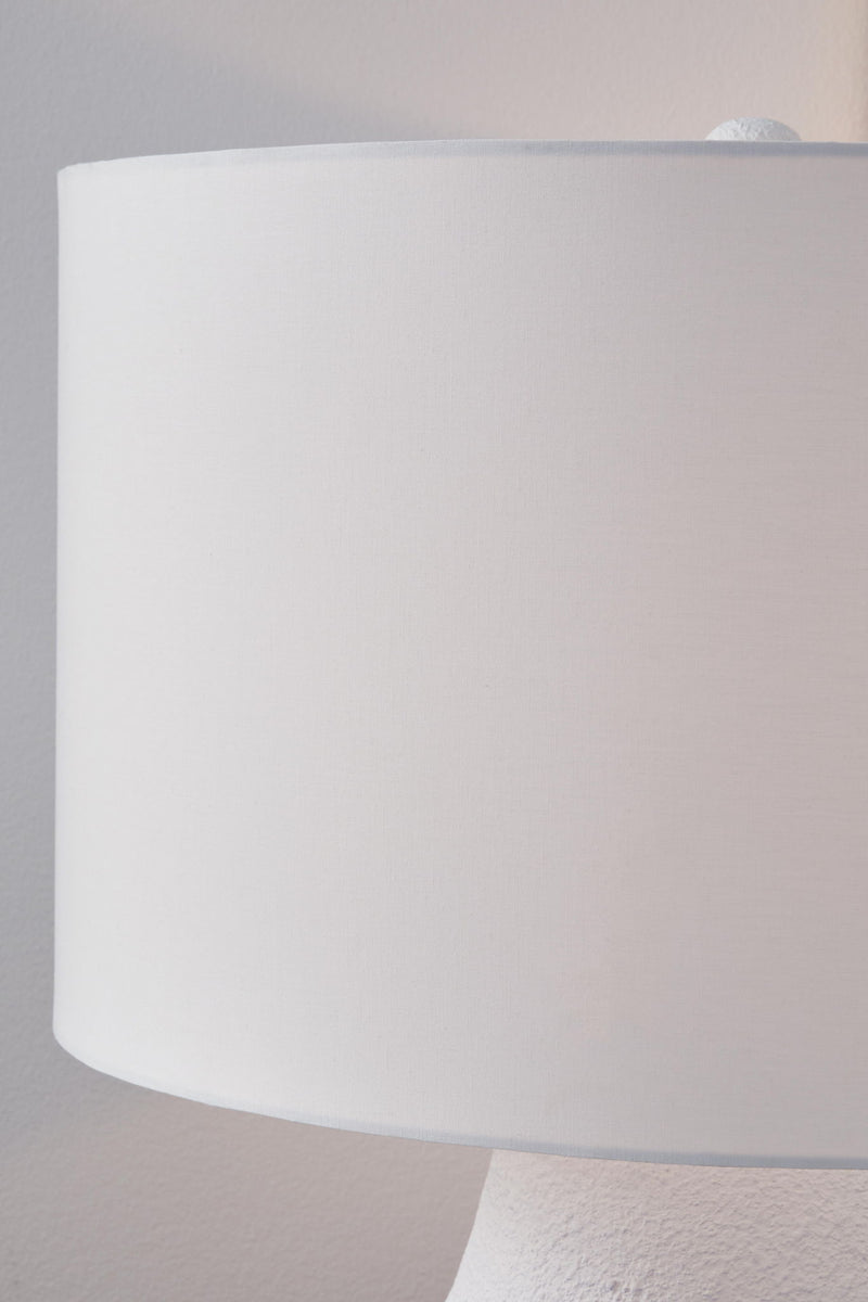 White and navy metal table lamp from Dashland by Signature Design Ashley, featuring a sleek modern design with a cylindrical base.