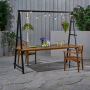 Noble House Huckleberry outdoor dining table with acacia wood finish, plant hanger, and teak accents for patio or garden.