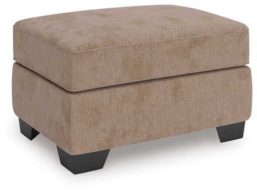 Benchcraft® Olten accent ottoman with plush fabric and wooden legs, used as a footstool or versatile living room accent piece.