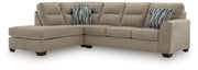 Olten stationary sectional sofa by Benchcraft®, featuring plush cushions and a modern design in a cozy living room setting.