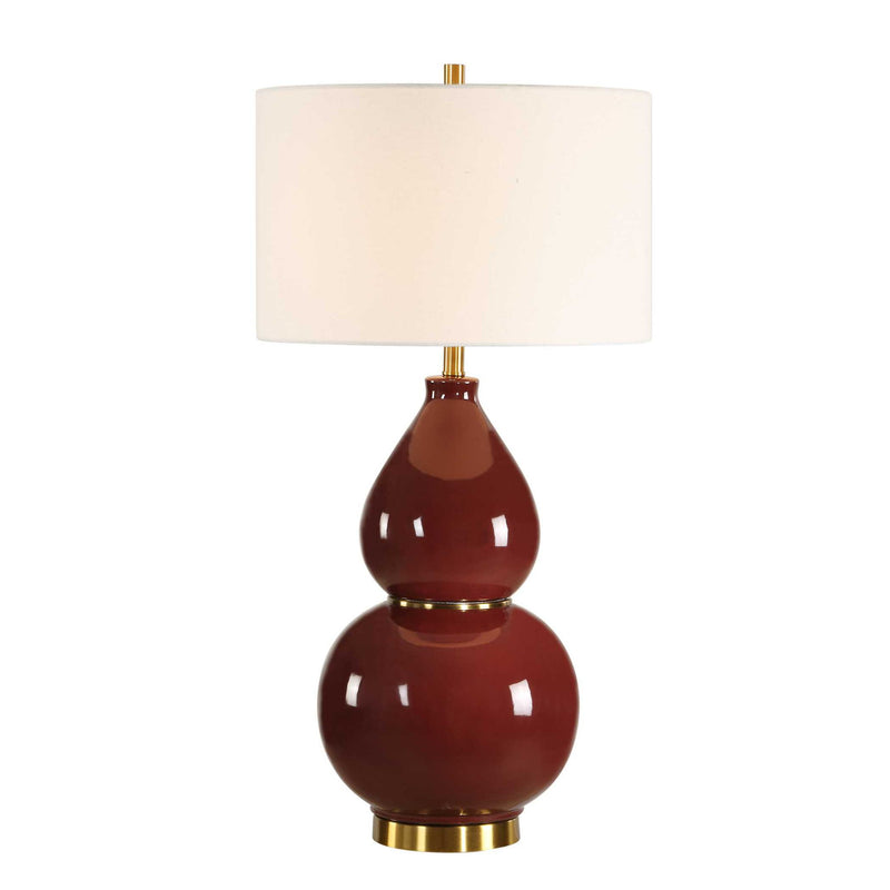Uttermost gourd-shaped table lamp with a textured ceramic base and fabric shade, placed on a wooden surface.