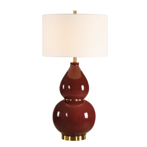 Uttermost gourd-shaped table lamp with a textured ceramic base and fabric shade, placed on a wooden surface.