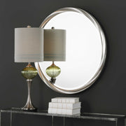 Round silver wall mirror by Uttermost with a sleek, modern frame reflecting a stylish interior decor.
