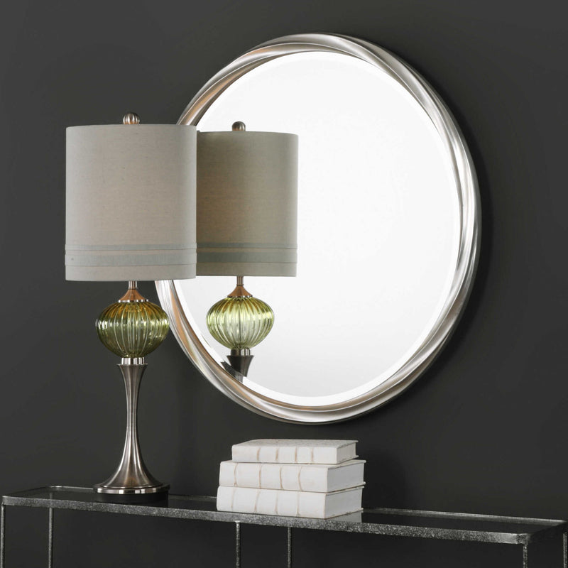 Round silver wall mirror by Uttermost with a sleek, modern frame reflecting a stylish interior decor.