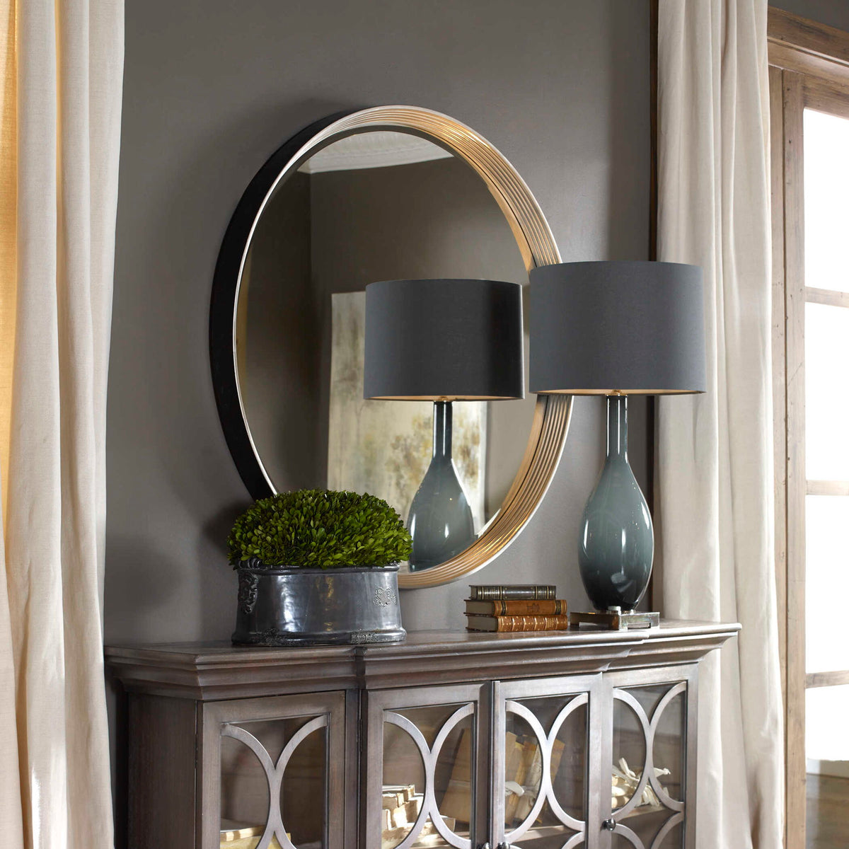 Uttermost Serenza round wall mirror with silver frame, reflecting a modern design for stylish home decor.