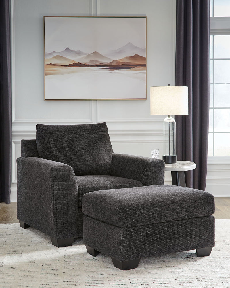 Benchcraft® stationary chair and ottoman from Loreo living room set, beige fabric with plush cushions and wooden legs.