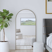Antique brass Crosley wall mirror with a sleek, modern design and a round shape, mounted on a neutral wall for stylish decor.