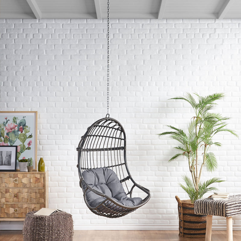 Rustic Noble House hanging basket chair with cushion, featuring woven design and cozy seating for outdoor or indoor relaxation.